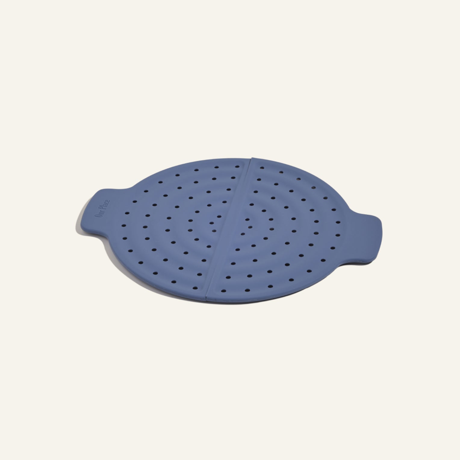 The Fearless Fry is a round, blue silicone steamer insert with side handles and multiple holes for splatter prevention, designed for use with the Always Pan and shown on a plain background.
