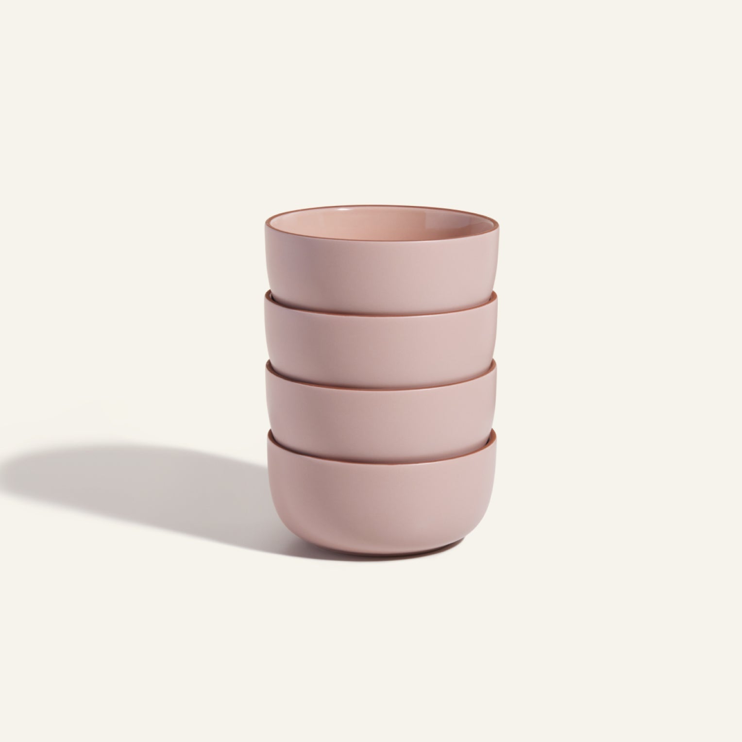 Four pink Soup Bowls are stacked neatly on a plain light background, highlighting a charming ceramic set that's perfect for stylish tableware.