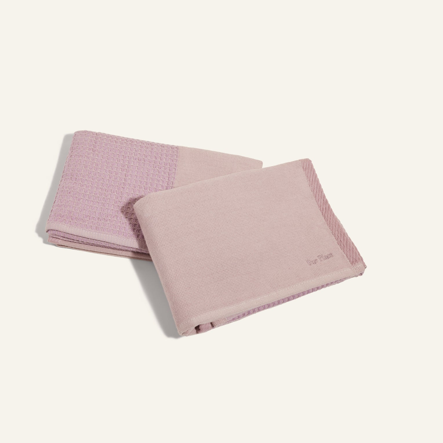 Two folded Double Dish Towels in light pink, featuring dual textures with a patterned section, are displayed on a plain light background.