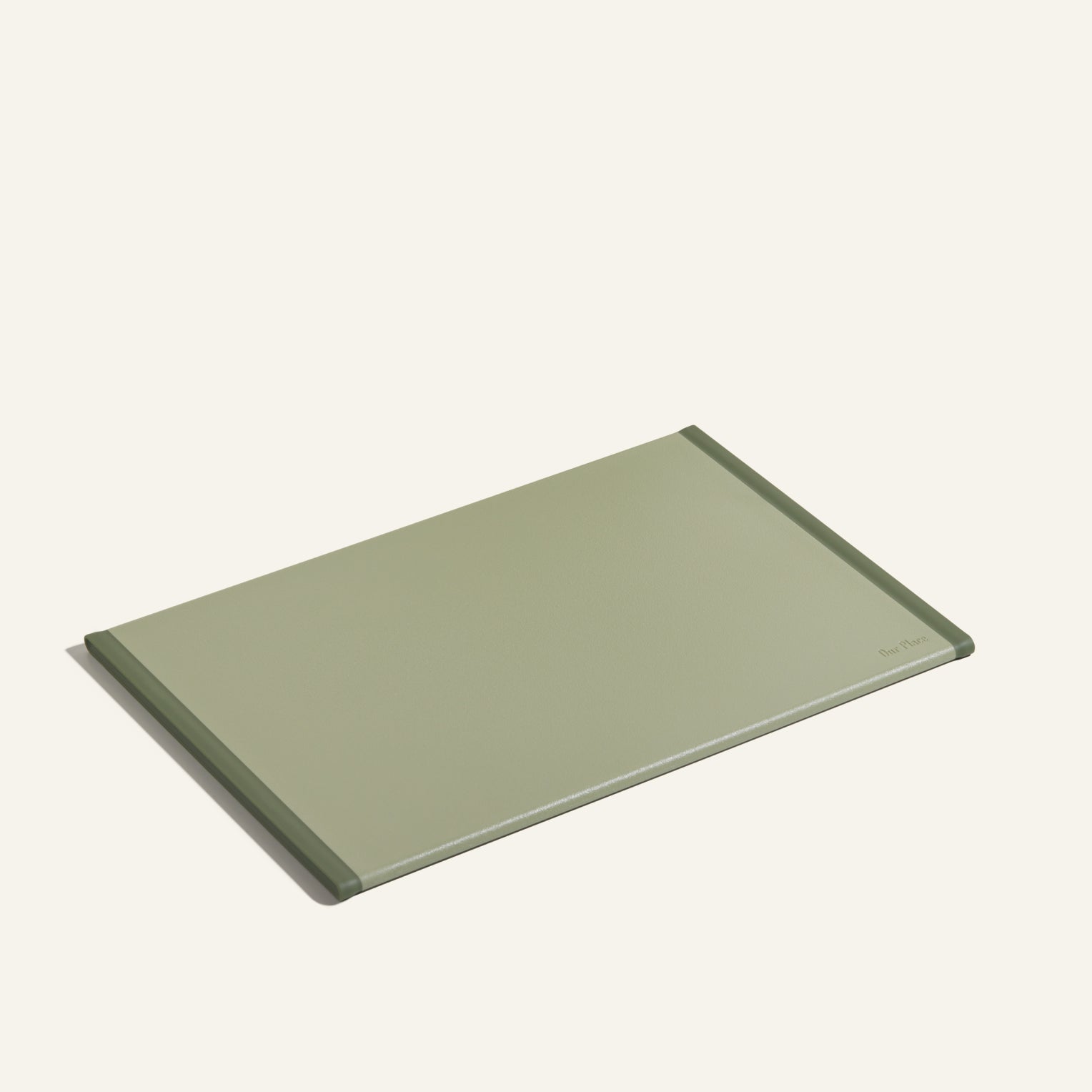 The Daily Board is a rectangular, light green cutting board made from recycled materials with slightly raised edges—ideal for home cooking. Shown on a plain off-white background.