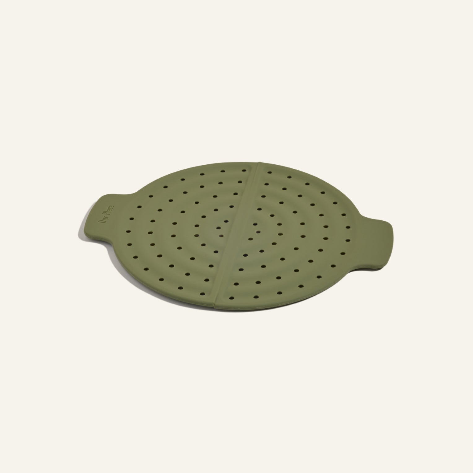 The Fearless Fry is a round, green silicone steamer lid with dual handles and evenly spaced holes to prevent splatter—perfect for use with your Always Pan.