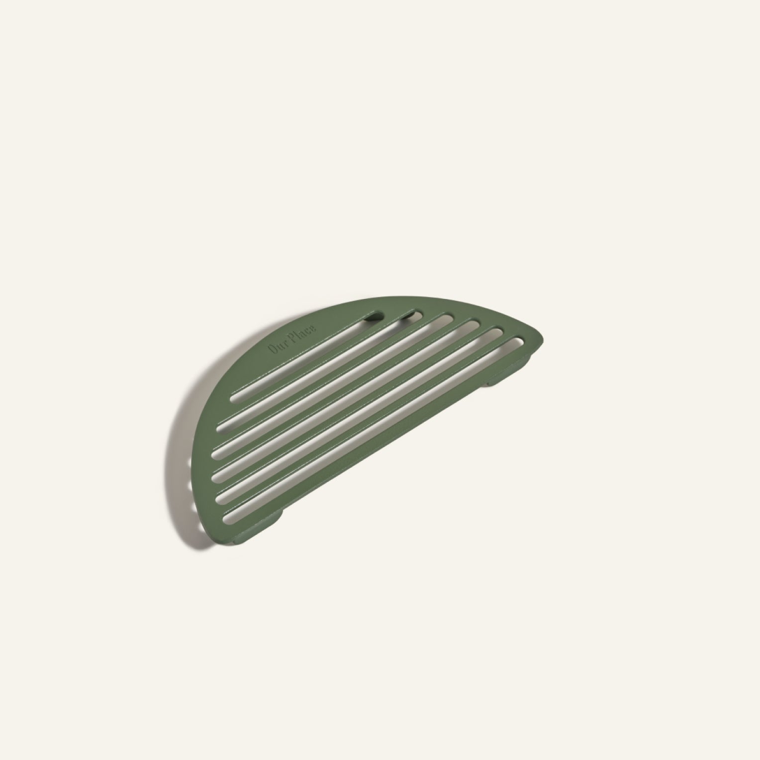 The Fry Deck, a green, semi-circular slotted soap dish with a center hole, lies flat on a plain, light background.