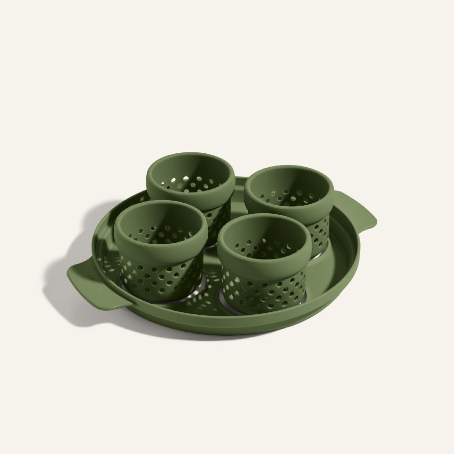 The Egg Poacher includes a green tray and four matching perforated silicone cups, all made of plastic—perfect for making poached eggs.