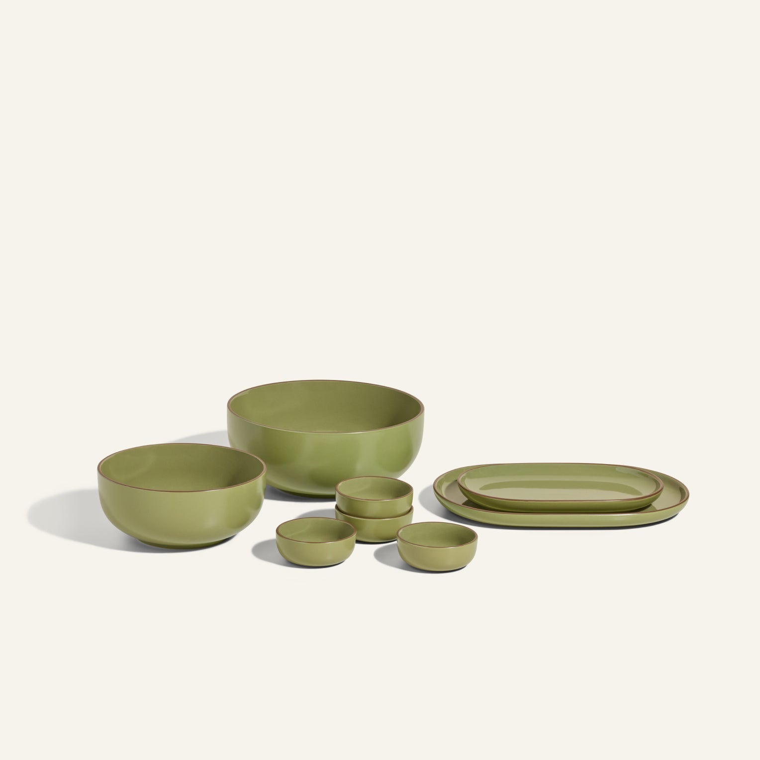 The Serving Set is a stylish 8-piece green ceramic collection with two large bowls, three small bowls, and two oval plates, arranged on a light background.