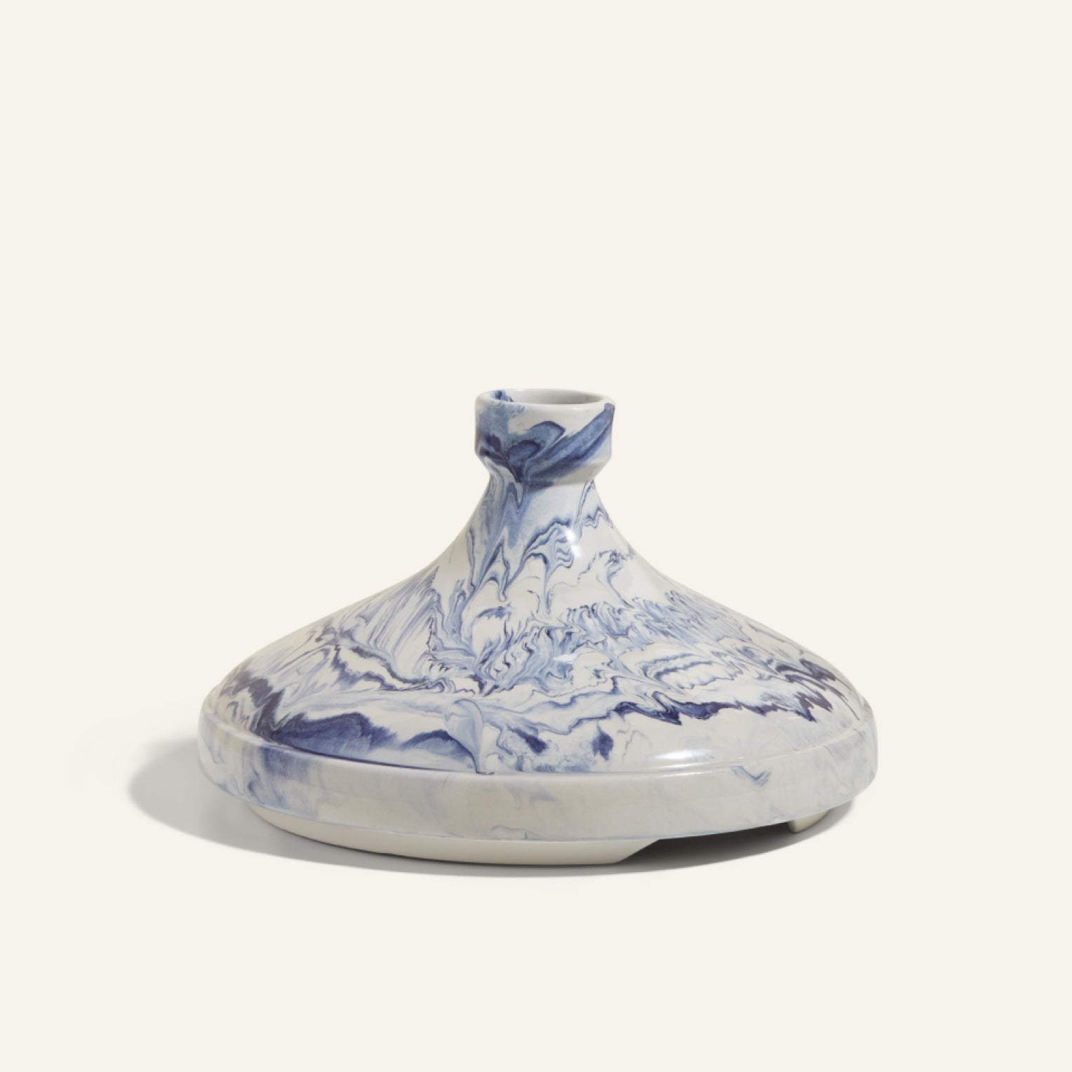 The Tagine features a clay lid with a marbled blue and white pattern, ideal for slow cooking and adding handcrafted Moroccan style to your kitchen.
