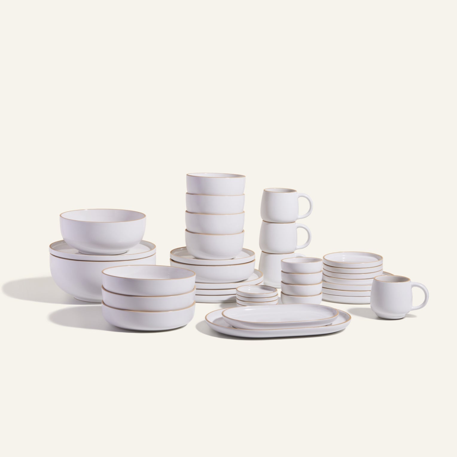 The Complete Stacking Set is a white ceramic collection of plates, bowls, mugs, and saucers arranged on a light background—ideal for upgrading your dinner party serveware.
