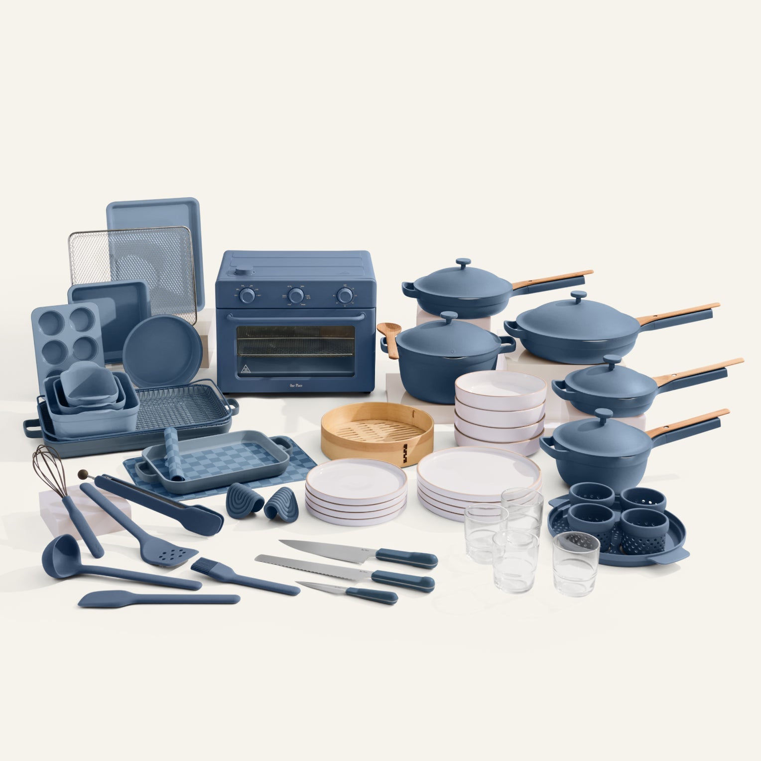 Collection of blue kitchenware including pots, pans, utensils, and cookware on a white background
