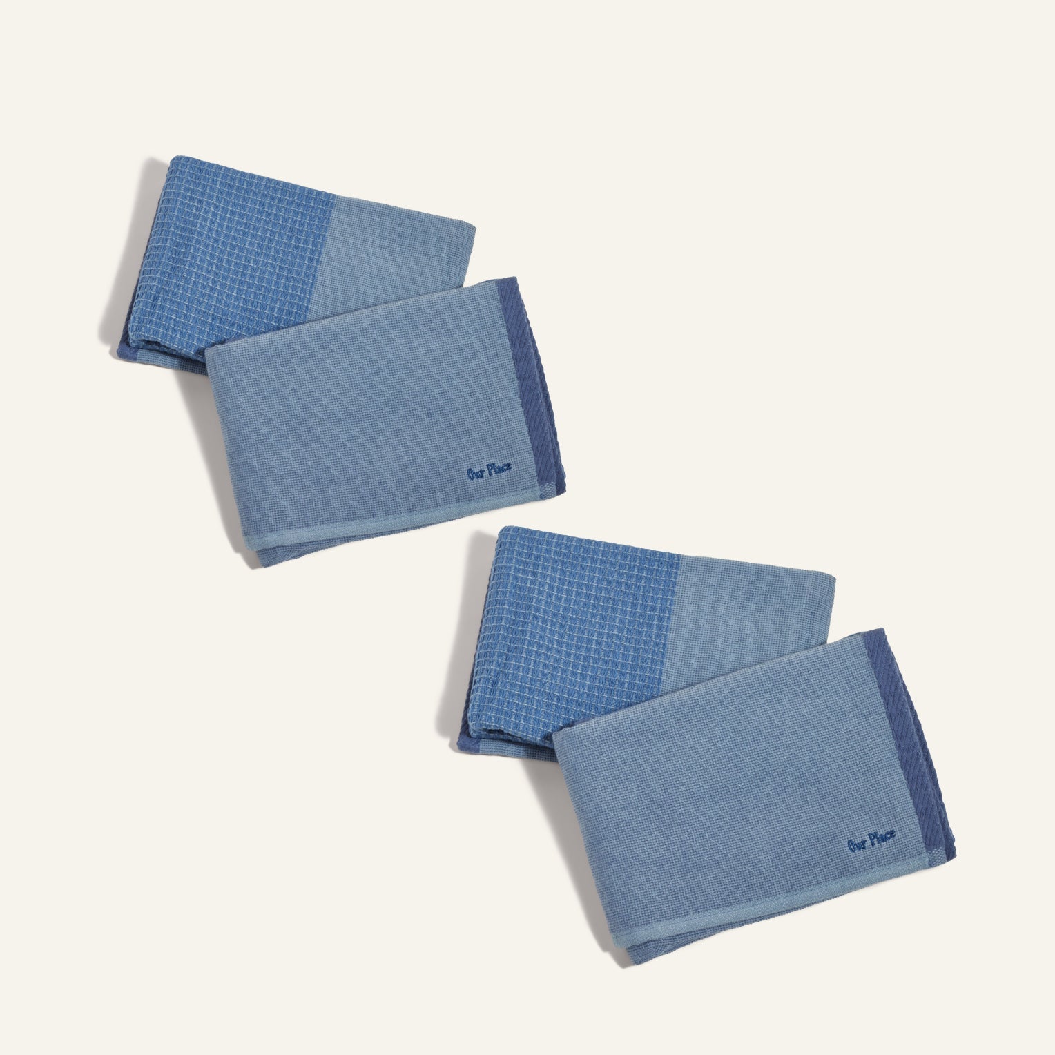 Four Double Dish Towels featuring two-tone blue patterns are folded and arranged diagonally on a light background, showcasing their dual-textured design.