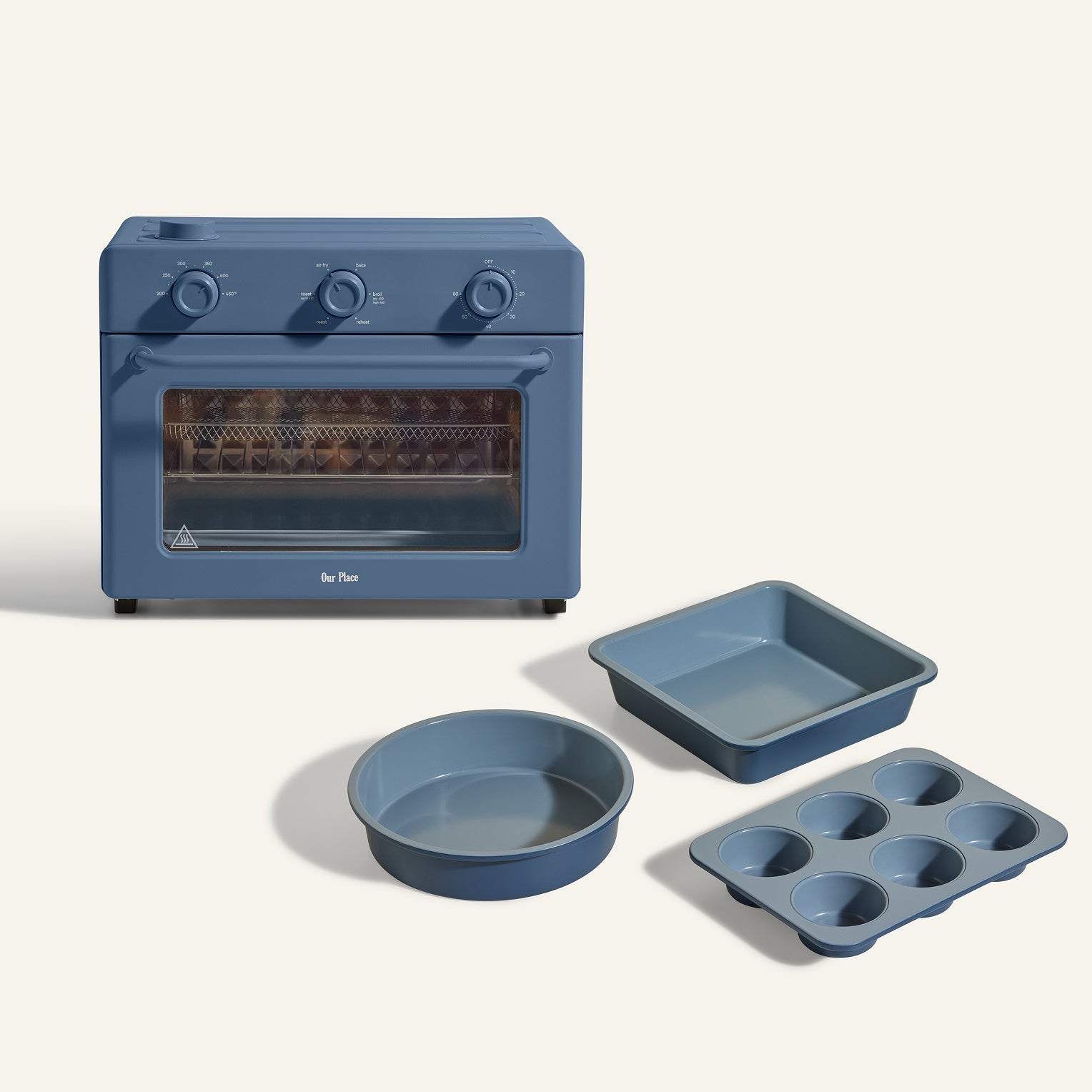 The Large Wonder Oven + Wonder Oven Baker's Kit is shown in blue with a round cake pan, square baking pan, and six-cup muffin tin, all displayed on a light background.
