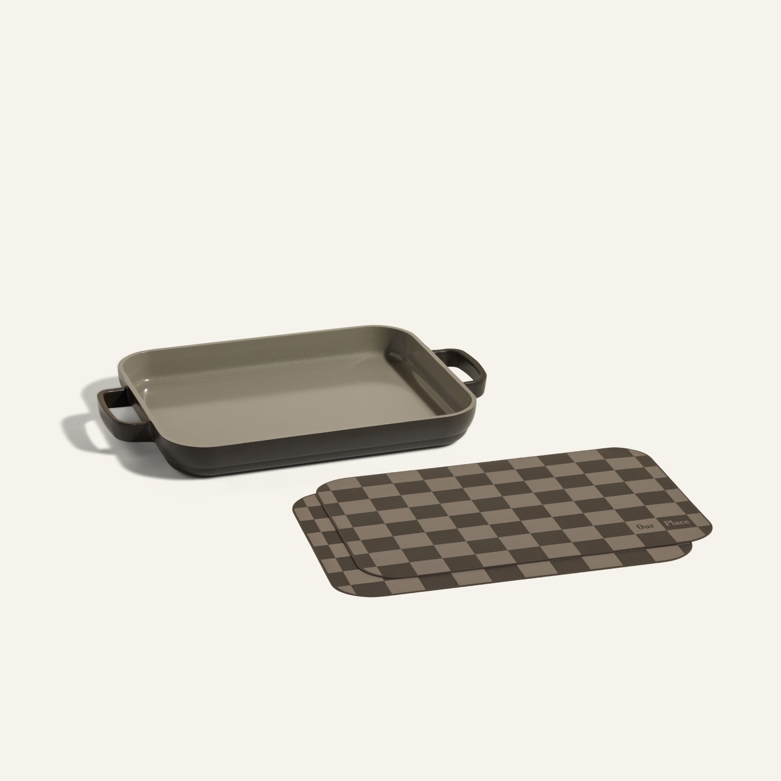Mini Griddle Pan with handles sits beside checkered-pattern Mini Oven Mats, both in neutral tones, displayed on a light background.