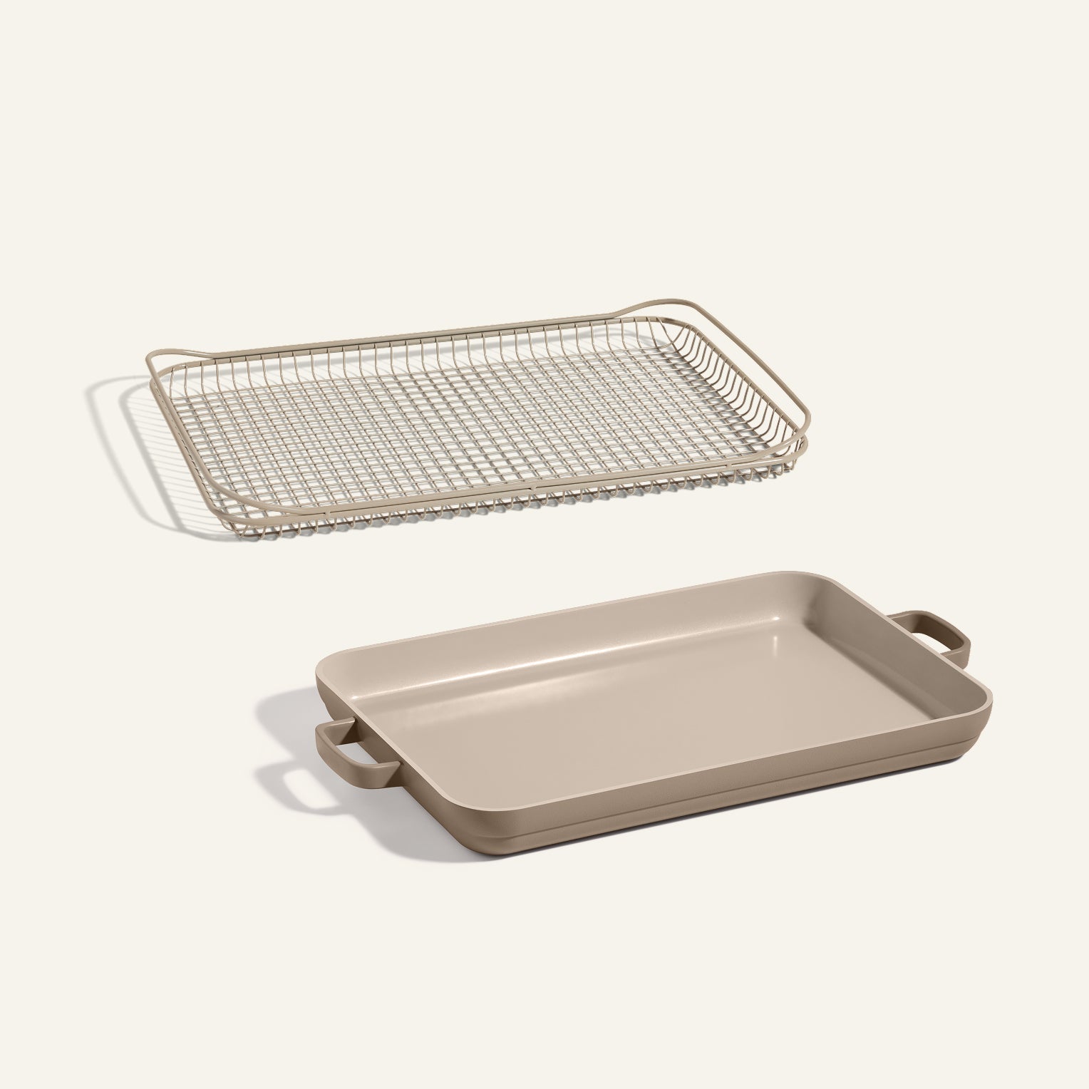 The Oven Rack + Griddle Pan set, featuring a beige rectangular pan with handles, is displayed beneath its matching wire rack against a plain light background.