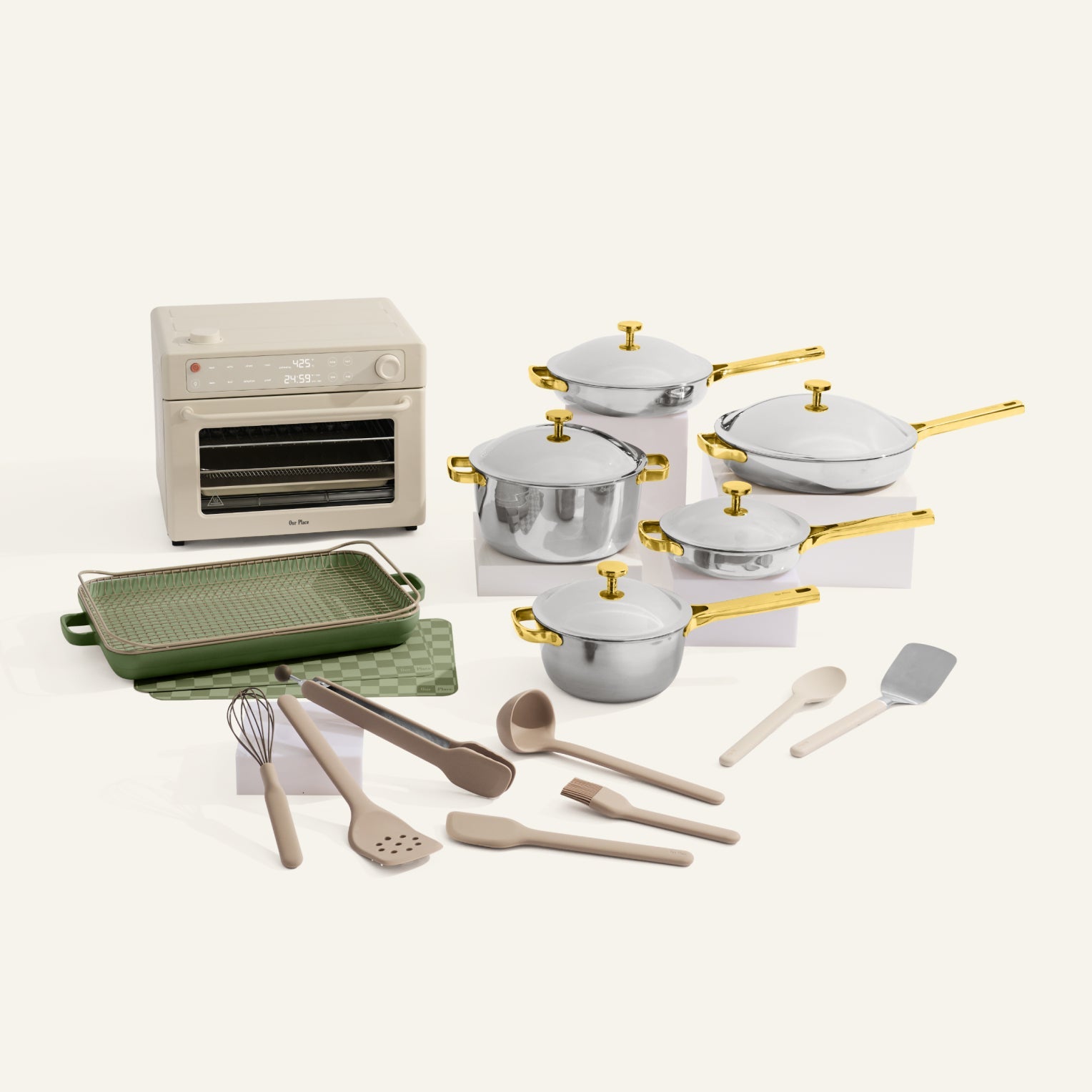Set of cookware including pots, pans, and kitchen utensils on a white background