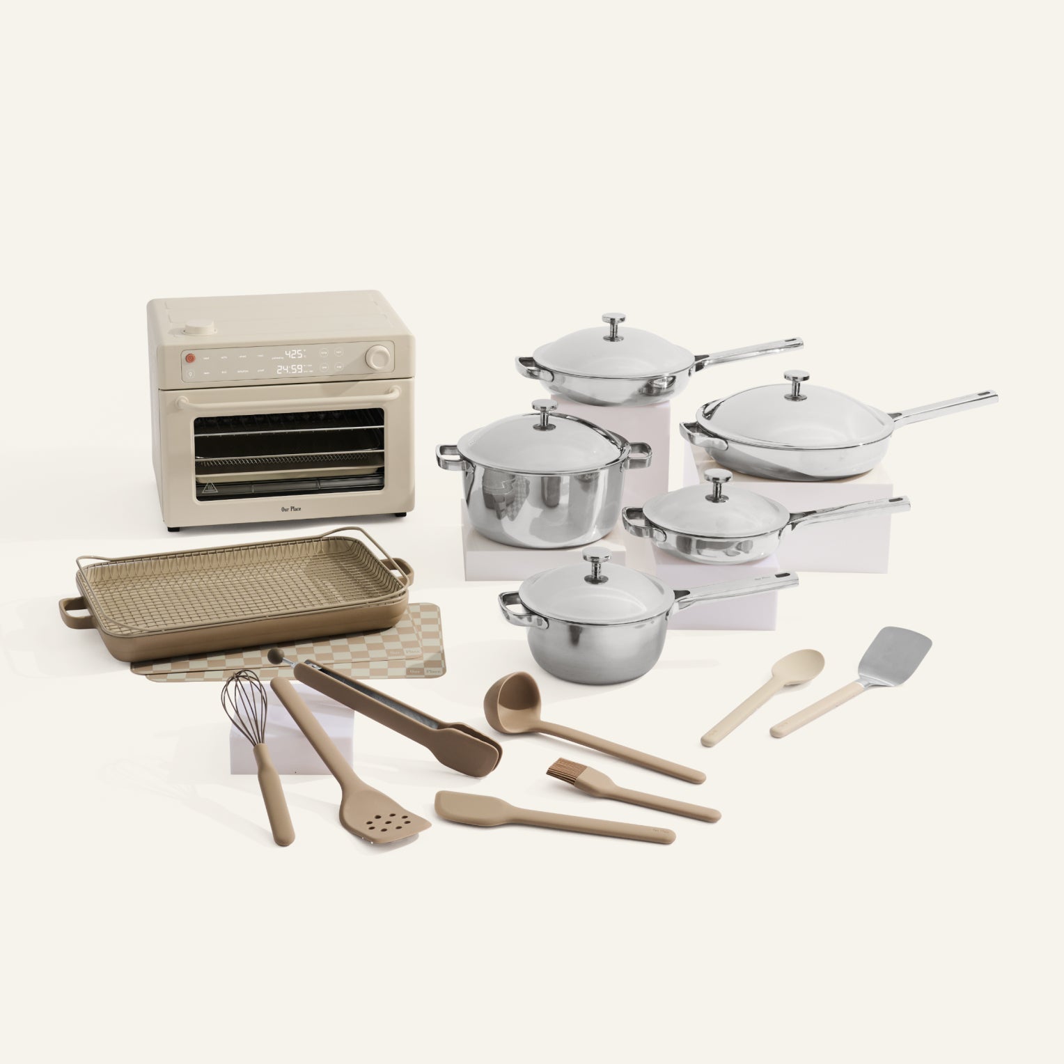 Kitchen appliance set including an oven, cookware, and utensils on a white background