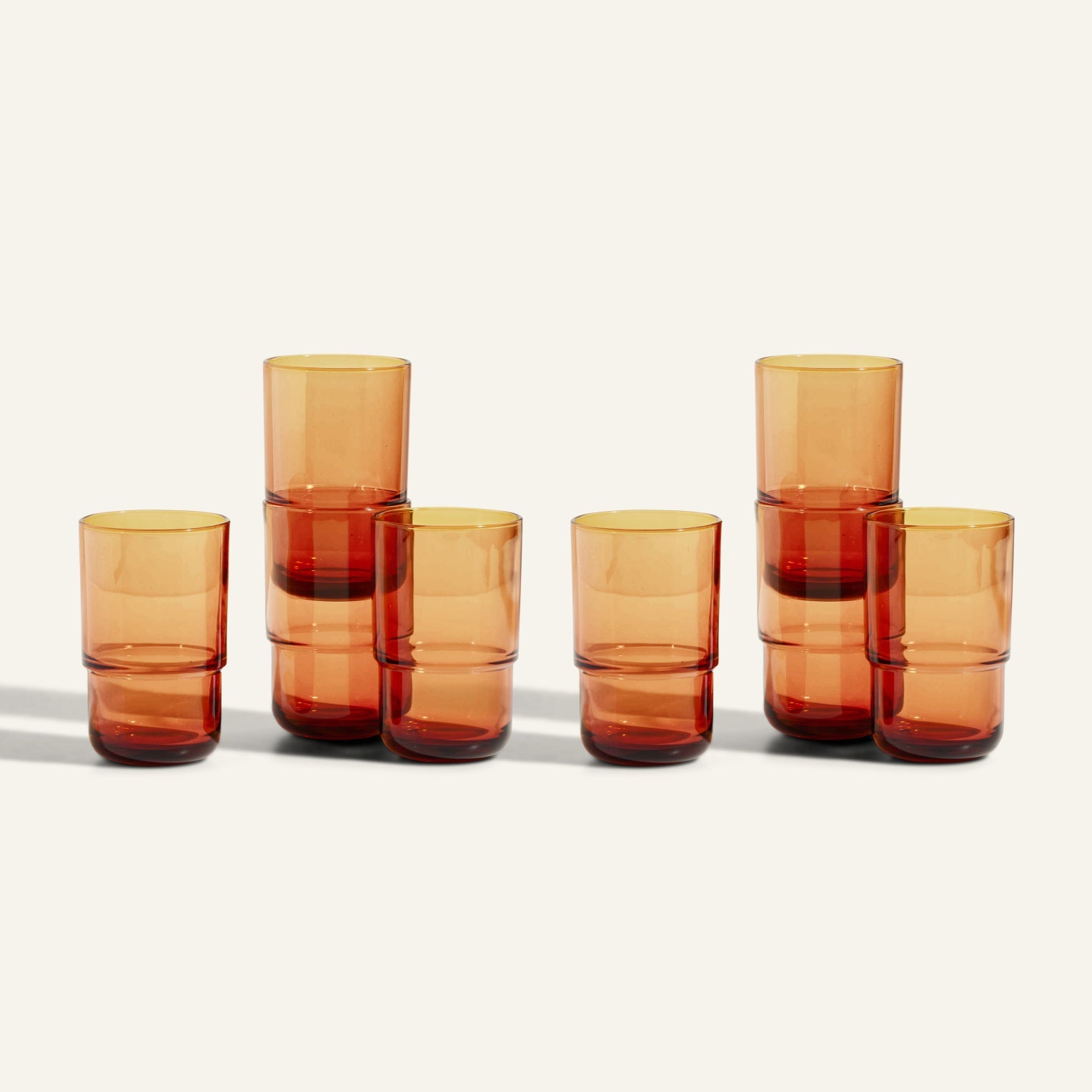 Six Tall Night + Day Glasses in amber are stacked in three groups of two, displayed against a plain light background.