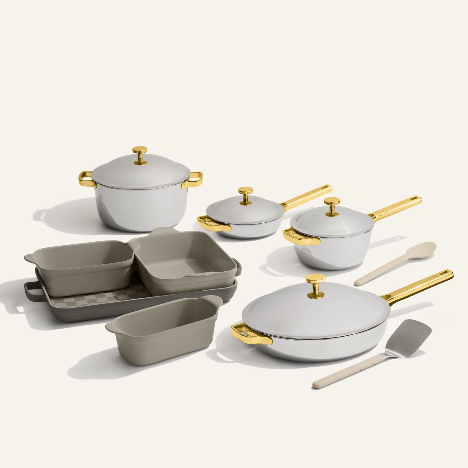 The VIP Titanium Pro Complete Cookware + Bakeware Set, featuring white and gold titanium pots, pans, nonstick bakeware, a spatula, and a spoon, is displayed on a neutral background.