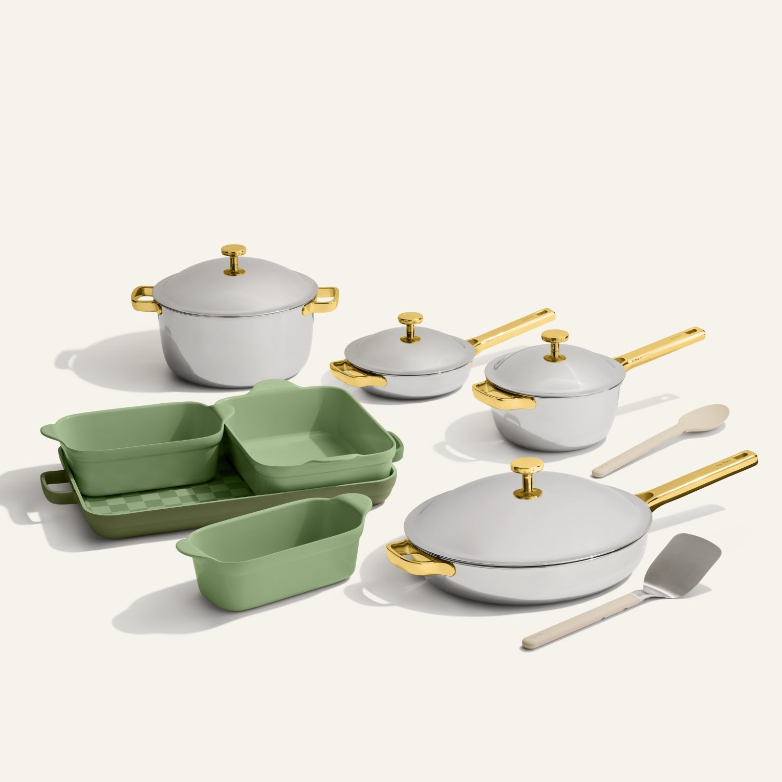 The VIP Titanium Pro Complete Cookware + Bakeware Set features elegant white and gold titanium pots, pans, and lids, paired with green nonstick bakeware trays and two utensils, beautifully arranged on a light background.
