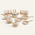 Set of ceramic cookware with gold handles on a white background
