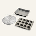 Set of three baking trays including a round perforated tray, a square tray, and a muffin tray on a white background.